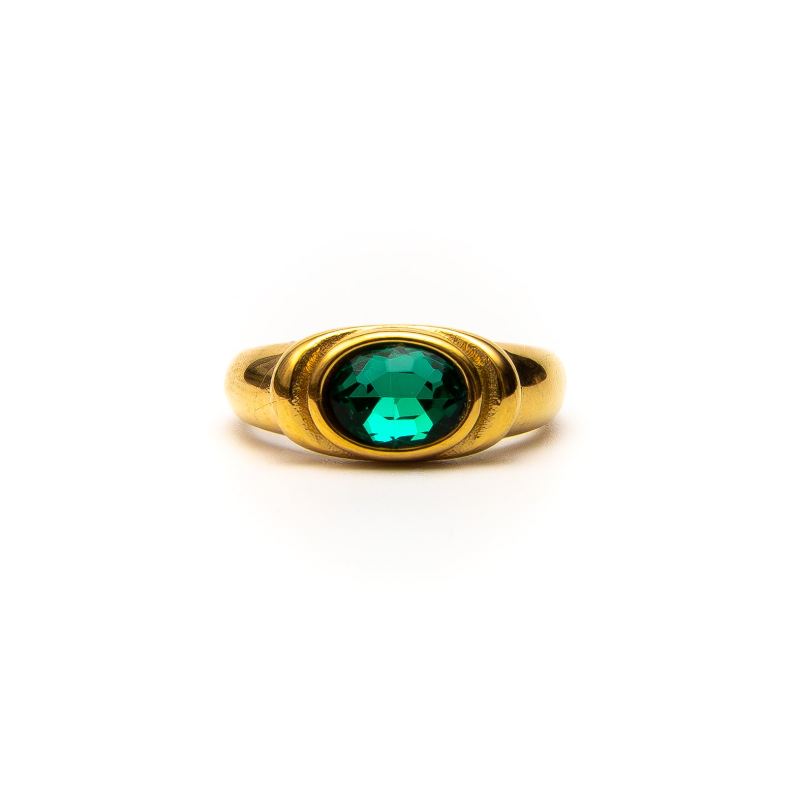 Gold ring with a green gemstone on a white background