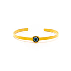 Yellow bracelet with a blue evil eye charm on a white background