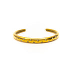 Gold bracelet with small stones on a white background