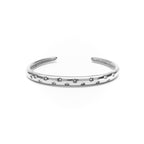 Silver bracelet with star patterns on a white background